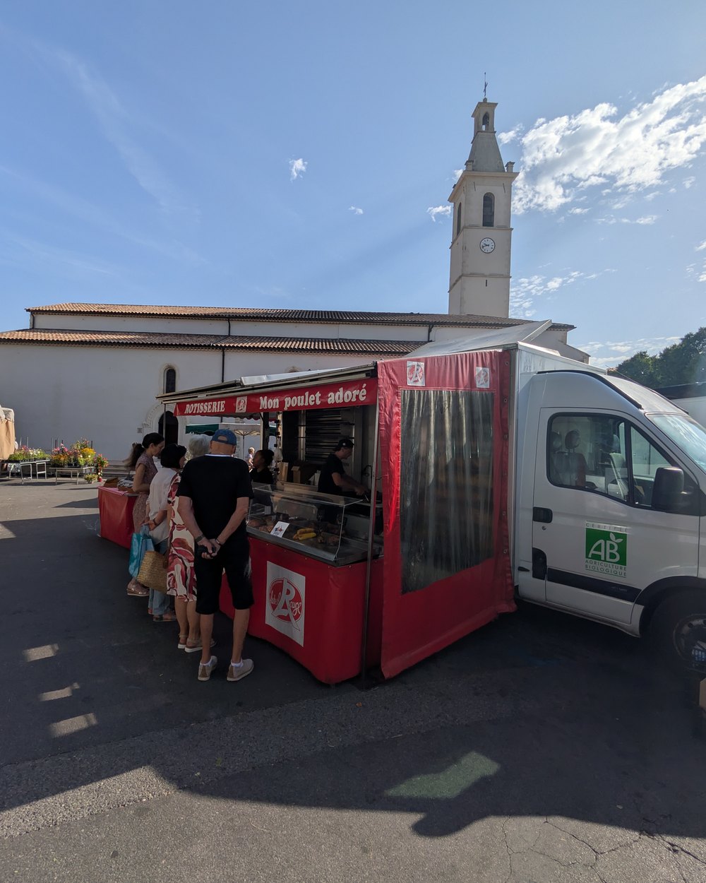 Le camion de Mon Poulet Adoré sur la place du marché d'Oraison, au pied du clocher.